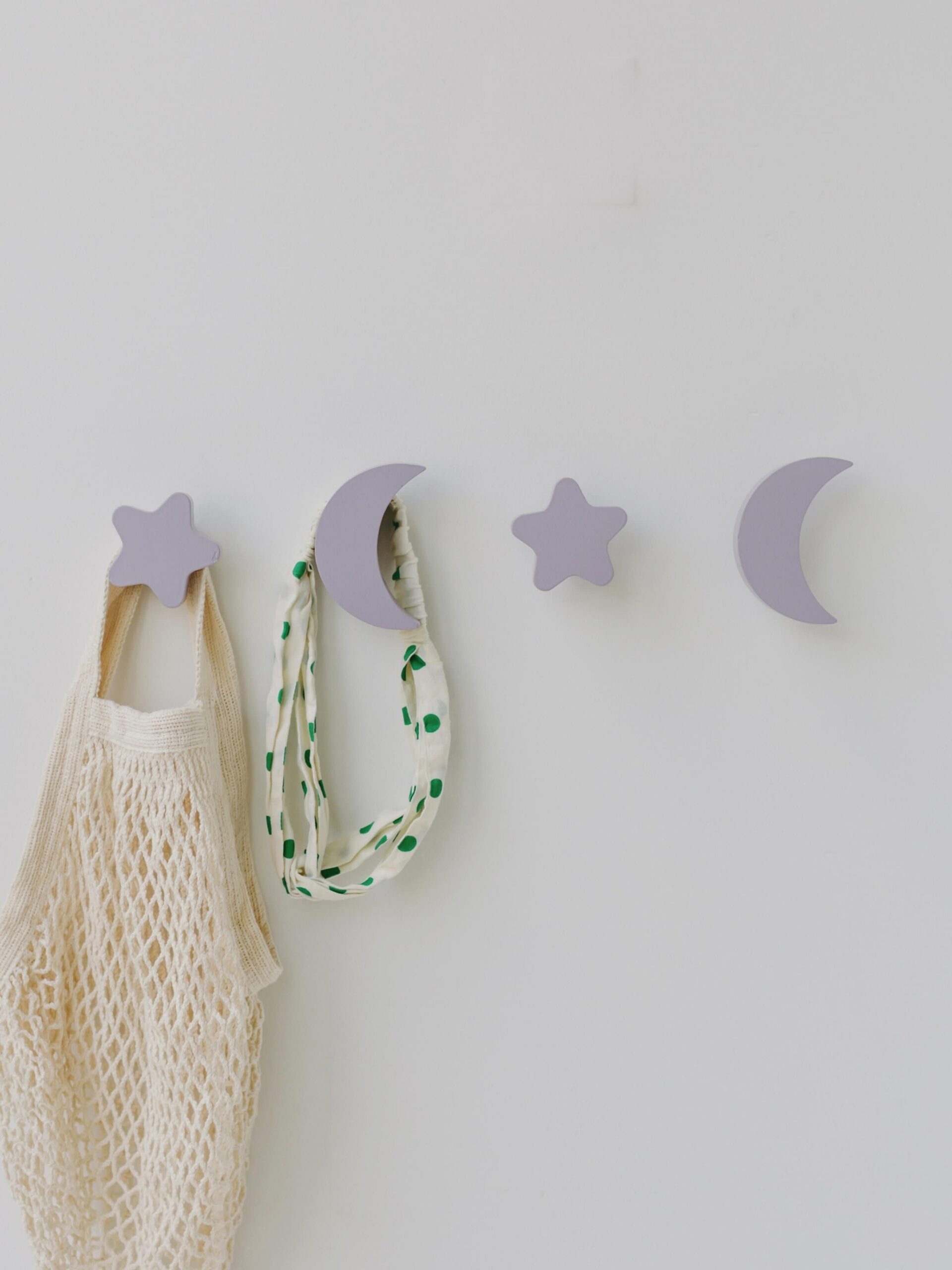 Levandų spalvos Nofred sieniniai kabliukai „Sky“ iš bukmedžio, mėnulio ir žvaigždžių formos, pritvirtinti prie sienos, su pakabintais aksesuarais.